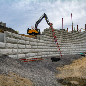 A side view of a half built stone wall.