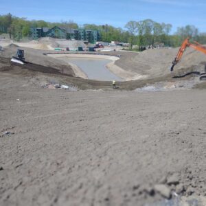 Body of water with excavator to the side.