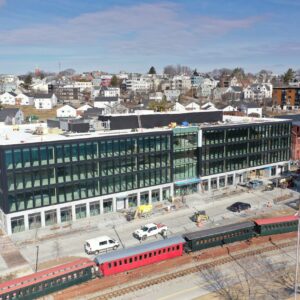 New modern structure in Portland with old railway in front.