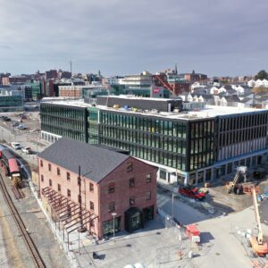 A new modern office building next to older brick building.