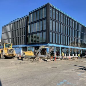 Construction equipment in front of a half-completed structure.