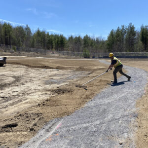Grondin worker raking site work gravel