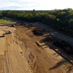 Aerial view of the job site with an older field in the background.