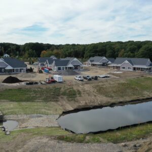 An aerial overview of the Piper Shores development site while it is under construction. In the foreground there is a pond with drainage leading to it.