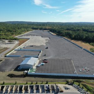 An aerial view of the Copart worksite showing a vast fenced in area with gravel being added to it.