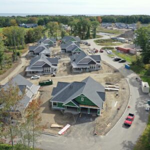 An aerial view showing the Piper Shores work site from the sky. The ocean is visible in the distance and many homes are under construction.