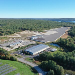 A high up aerial view of the Copart worksite, there is a grassy area with solar panels in the foreground.