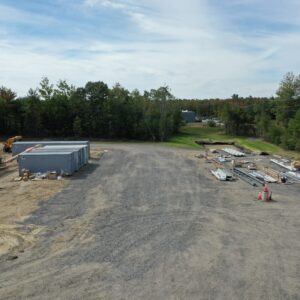 A wide gravel driveway with work trucks and construction materials at the Summit Church work site