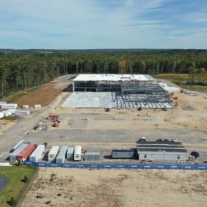 A high up aerial view of the IDEXX worksite with heavy metal framing being constructed in the center, a large building in progress.