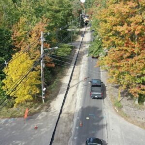 Aerial view of a road with the pavement removed from one lane, cars are driving in the other lane